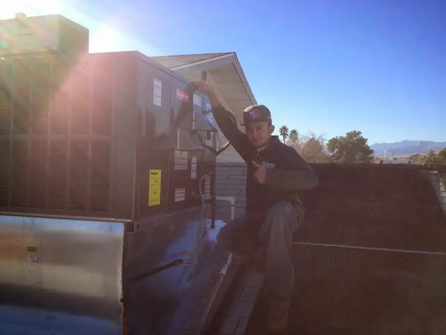 HVAC technician performing AC Tune-Up on a rooftop unit in Lakeville